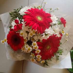 Kytice červenobílá z gerber, chrysantem, heřmánku a karafiátků.